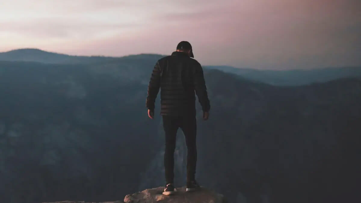 Man standing on mountain wearing a parka cleaned by ëClean